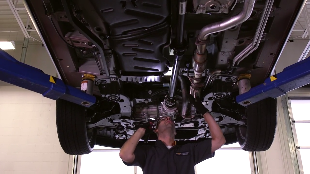 A General Motors Certified Service Professional performs expert Chevy service beneath a Chevrolet vehicle in City of Industry, CA