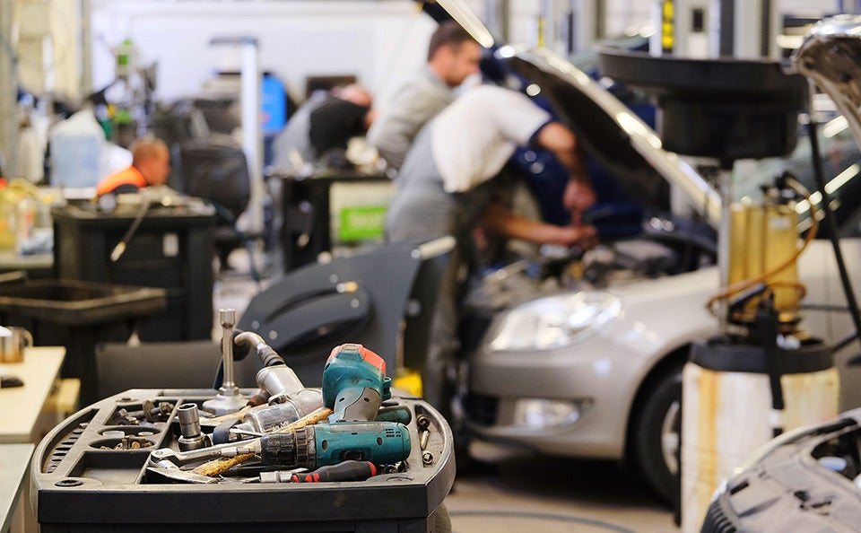 Auto repair shop with mechanics working on a vehicle.